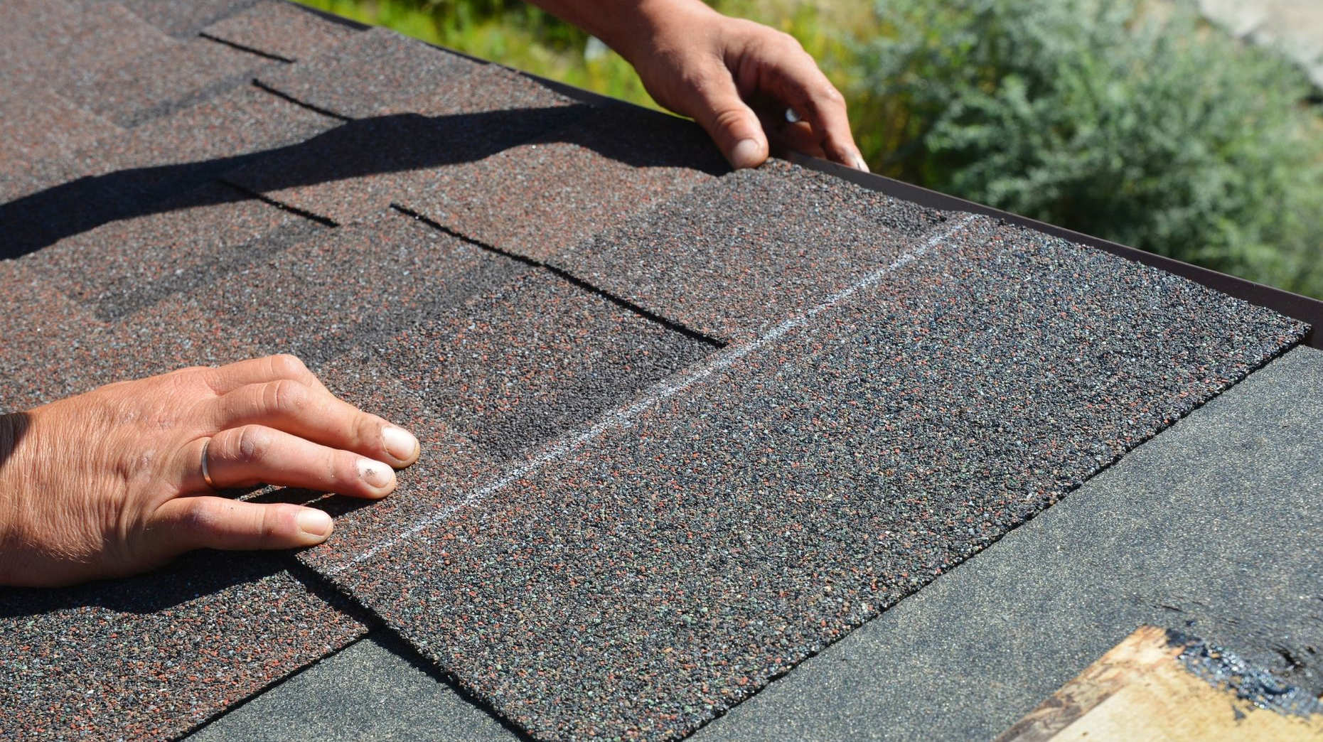 Worker installing shingles on a roof