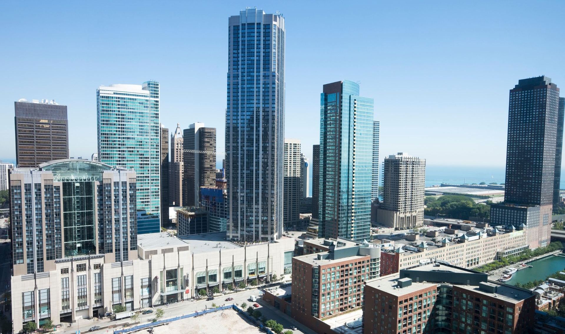 Downtown skyline with tall glass skyscrapers and a waterfront in the distance