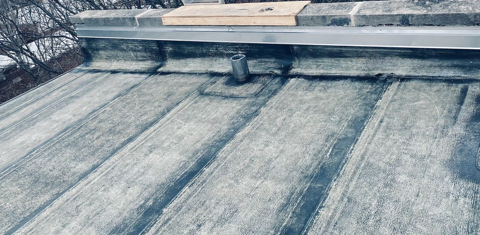 Flat rooftop showing dark seams and a vent near the top edge