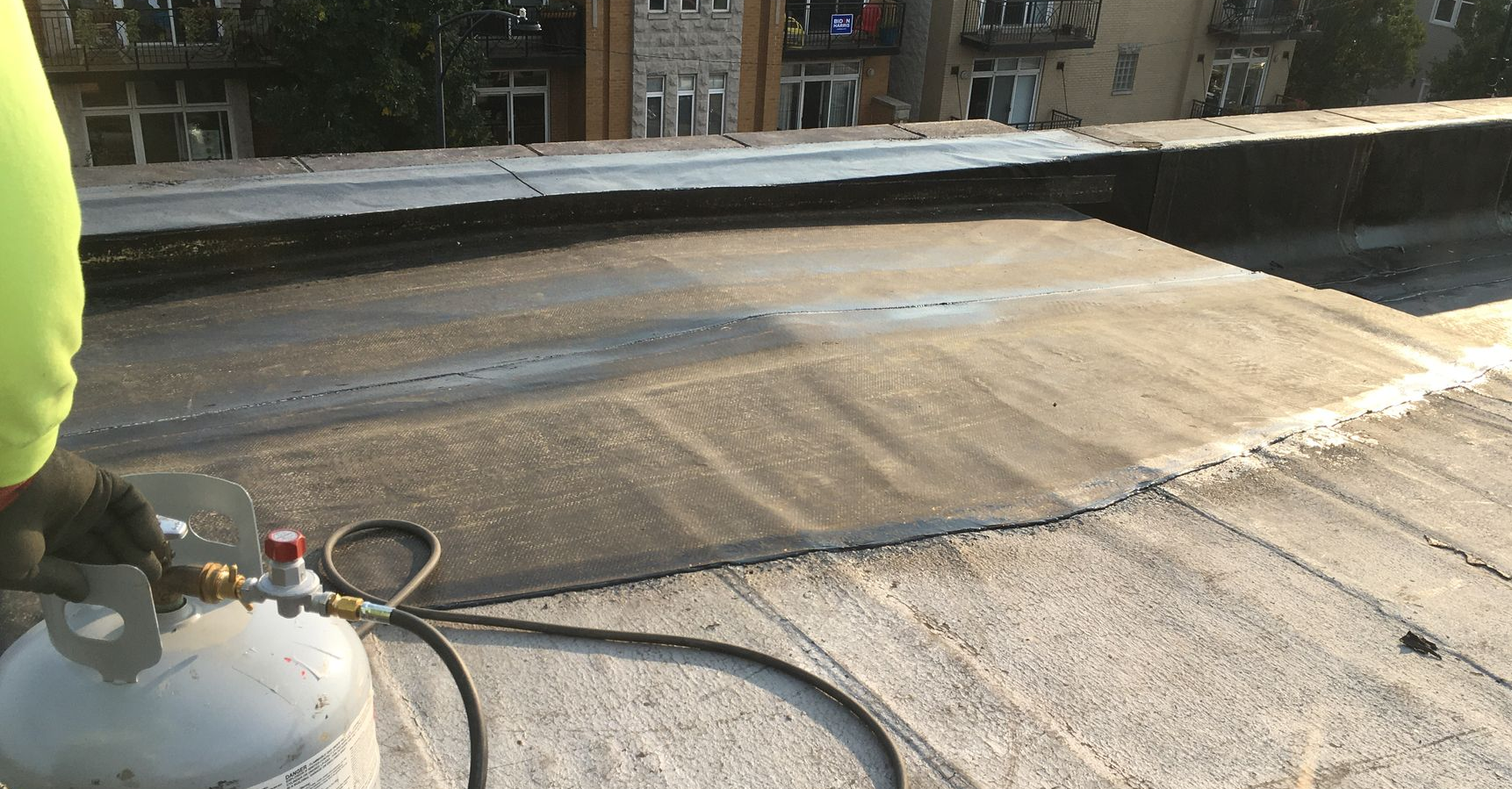 Worker with a container and tube on a rooftop