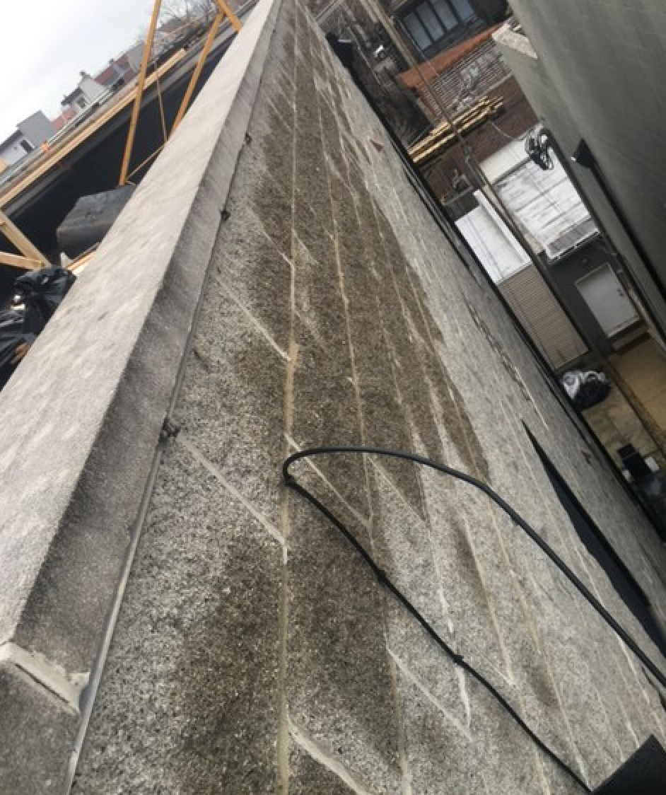 Water rushes to top of split face block parapet after WickRight vented drip edge is installed