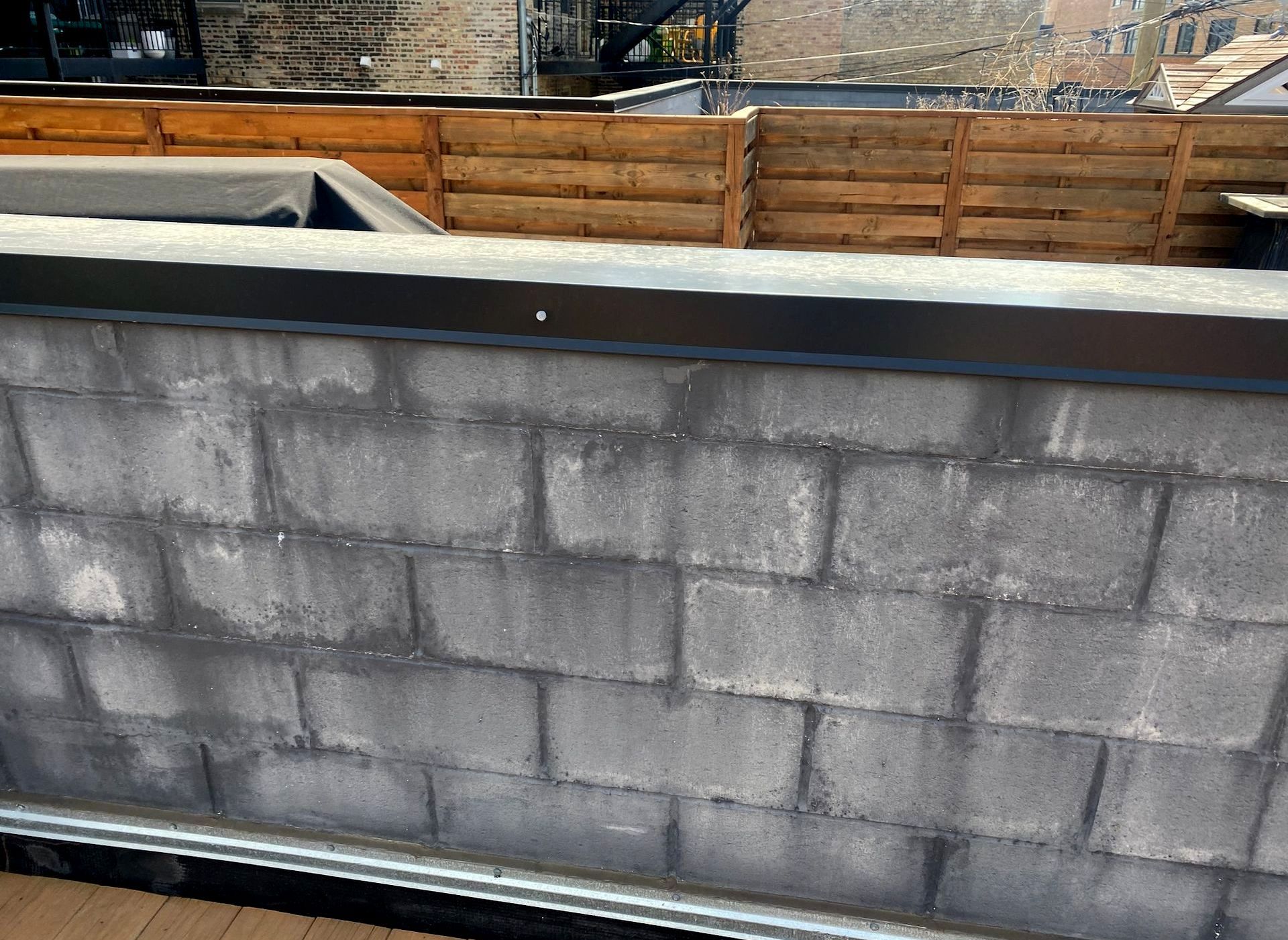 Extremely wet split face block parapet wall with efflorescence.