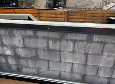 Extremely wet split face block parapet wall with efflorescence.
