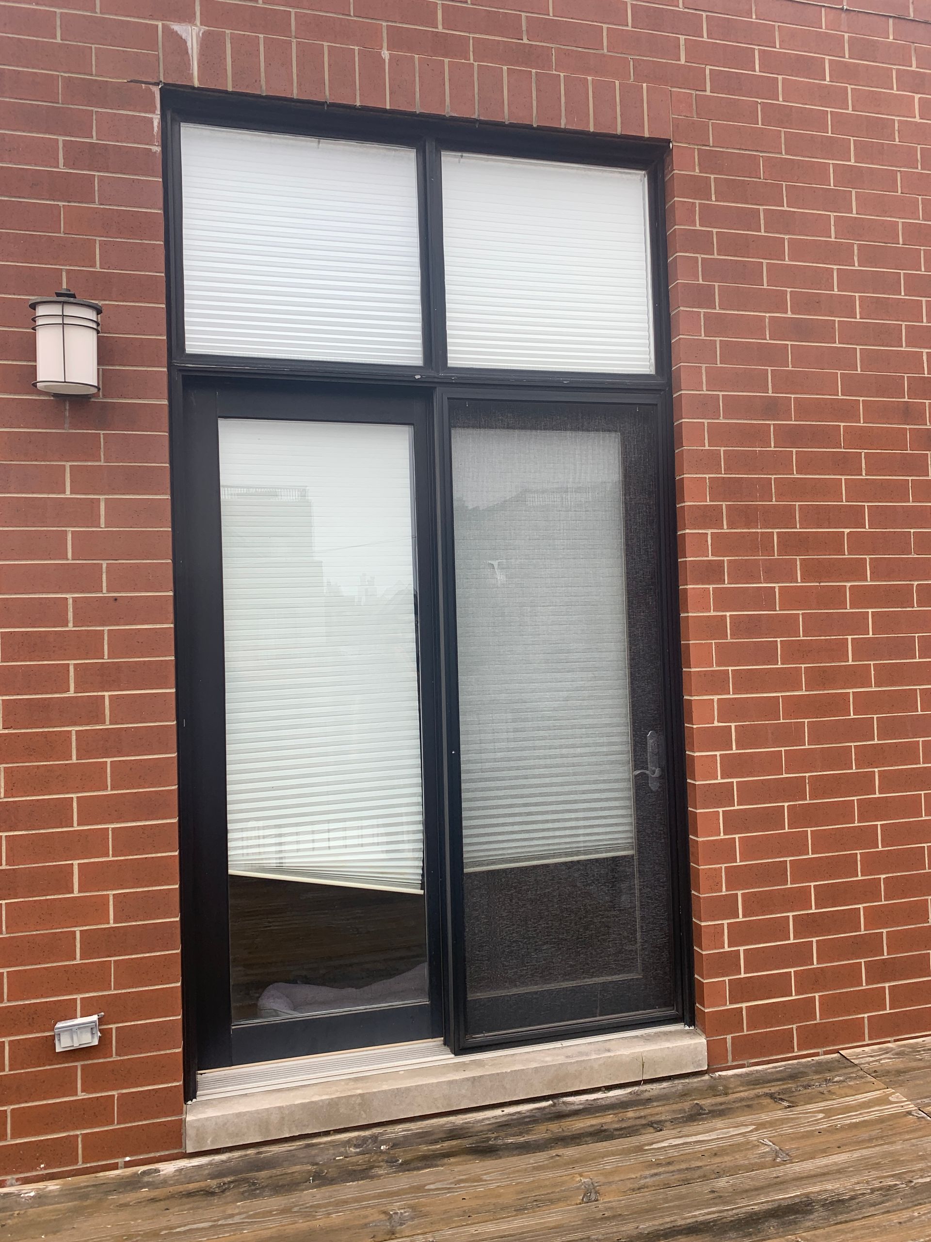 Sliding glass door onto rooftop deck, unflashed limestone sill allows rain and snow melt into door, Chicago