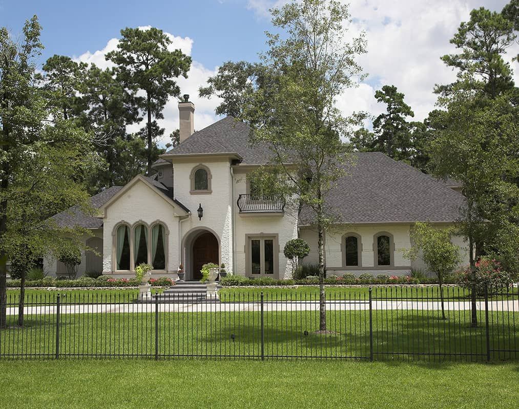 A large white house with a fence in front of it