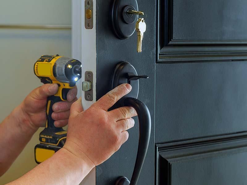 A person is fixing a door with a drill.
