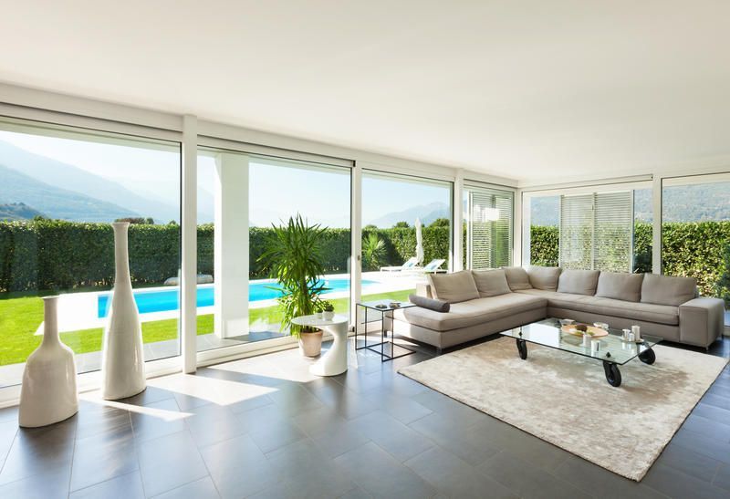 A living room with a large sectional couch and a glass coffee table
