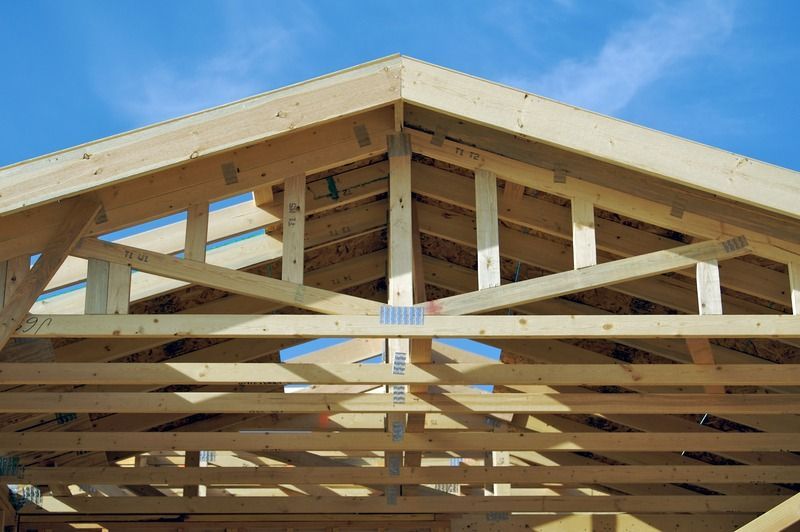A wooden structure under construction with a blue sky in the background.