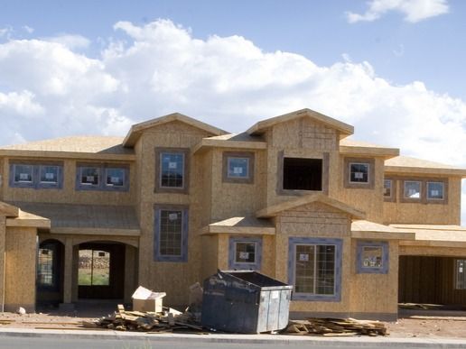 A large house under construction with a dumpster in front of it
