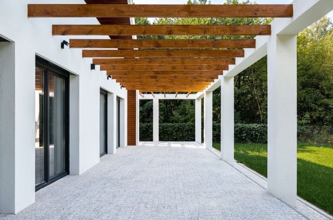 An empty patio with a wooden pergola over it