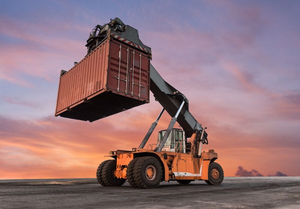 A Crane Is Lifting A Shipping Container Into The Air — Newcastle Moving & Storage in Salt Ash, NSW