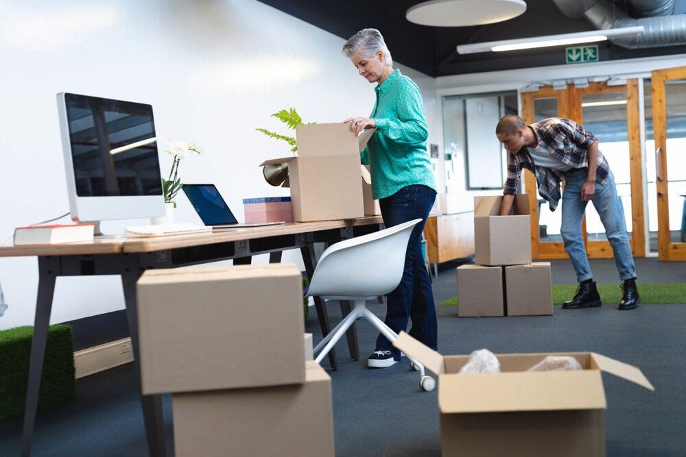 A Man And A Woman Are Moving Into A New Office — Newcastle Moving & Storage in Terrigal, NSW