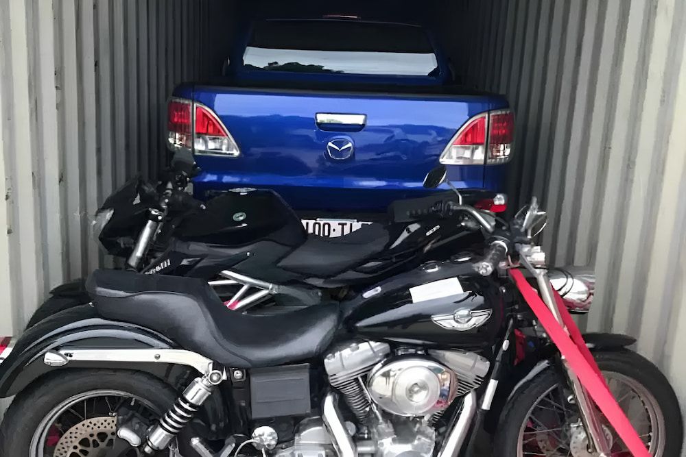 A Container Filled With Motorcycles And A Blue Truck — Newcastle Moving & Storage in Salt Ash, NSW