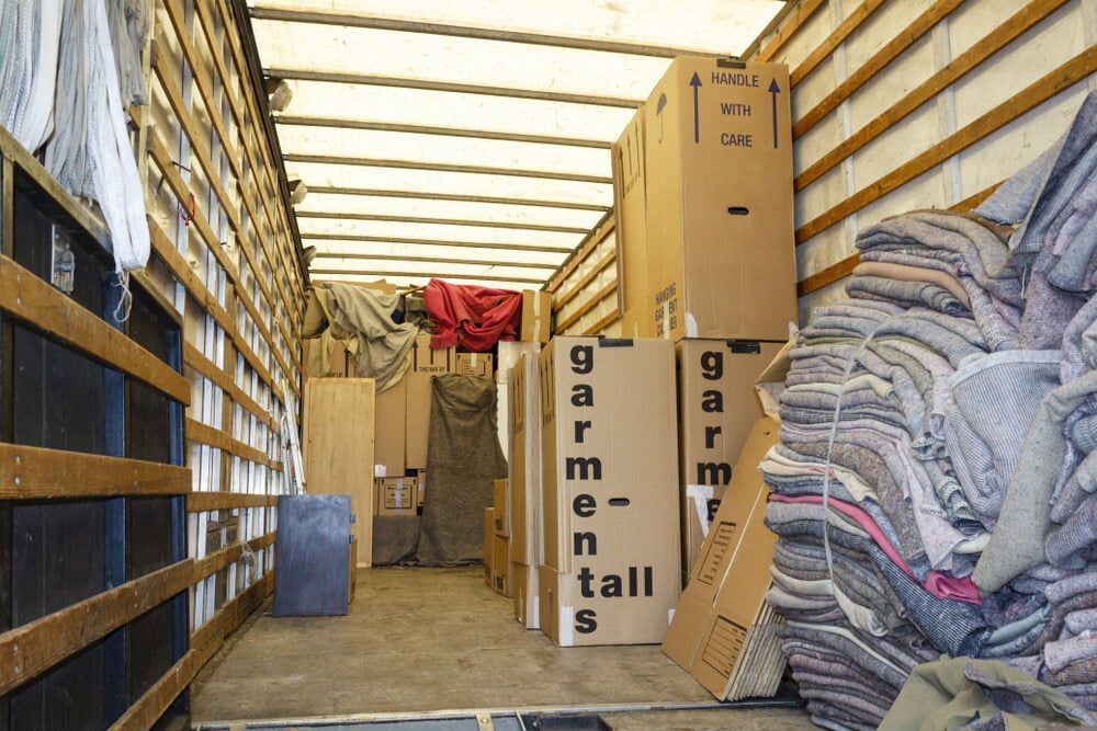 The Inside Of A Moving Truck Filled With Boxes And Blankets — Newcastle Moving & Storage in Salt Ash, NSW