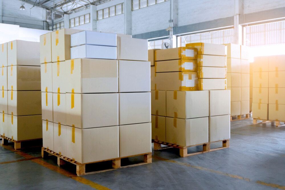 A Warehouse Filled With Lots Of Cardboard Boxes On Wooden Pallets — Newcastle Moving & Storage in Salt Ash, NSW