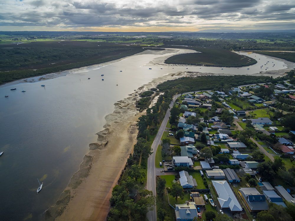 An Aerial View Of A River Surrounded By Houses And Trees — Newcastle Moving & Storage in Rutherford, NSW