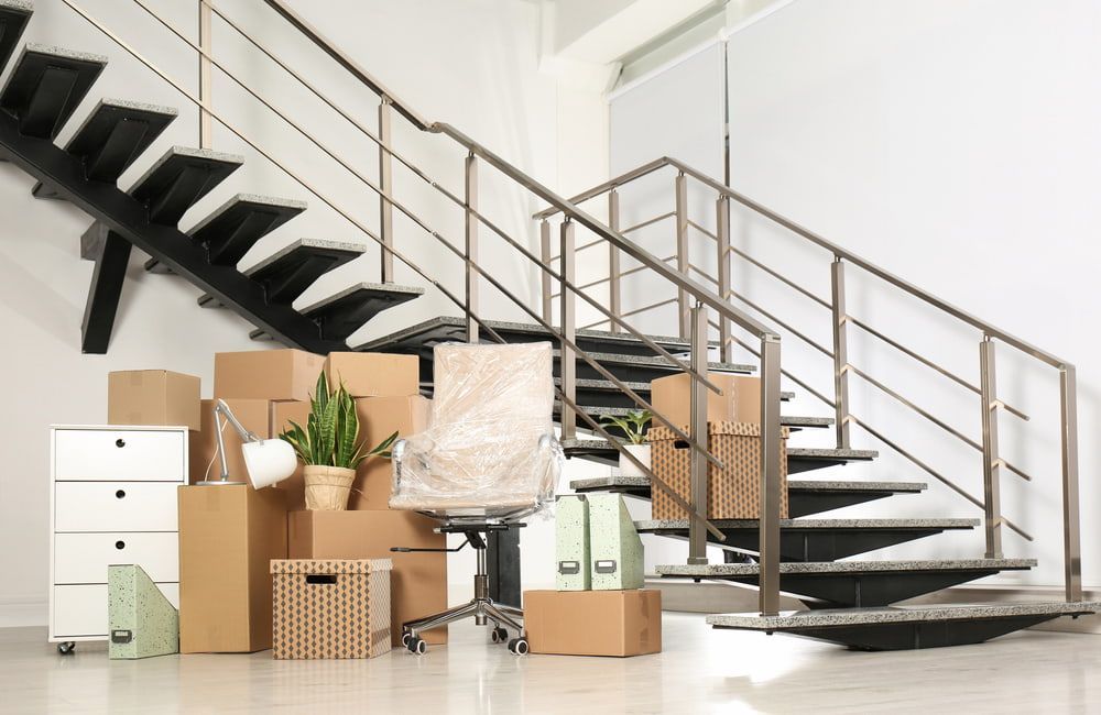 A Room With Stairs And Boxes On The Floor — Newcastle Moving & Storage in Salt Ash, NSW