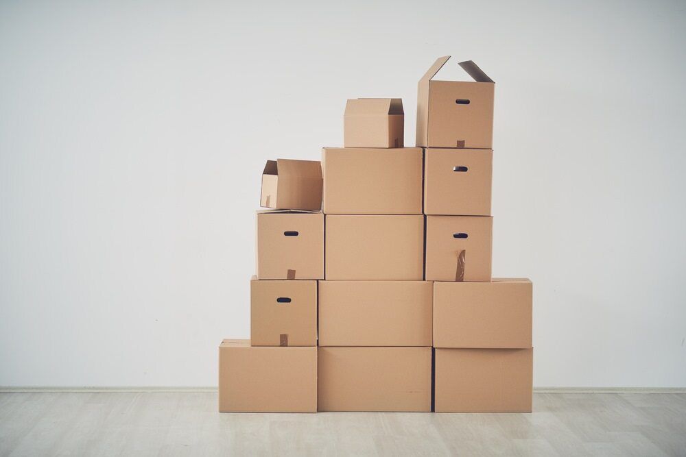A Stack Of Cardboard Boxes Stacked On Top Of Each Other In A Room — Newcastle Moving & Storage in Tuggerah, NSW
