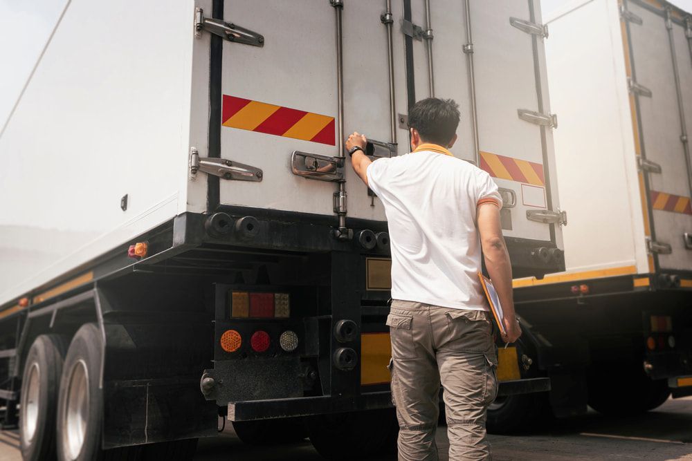 A Man Is Opening The Door Of A Semi Truck — Newcastle Moving & Storage in Salt Ash, NSW