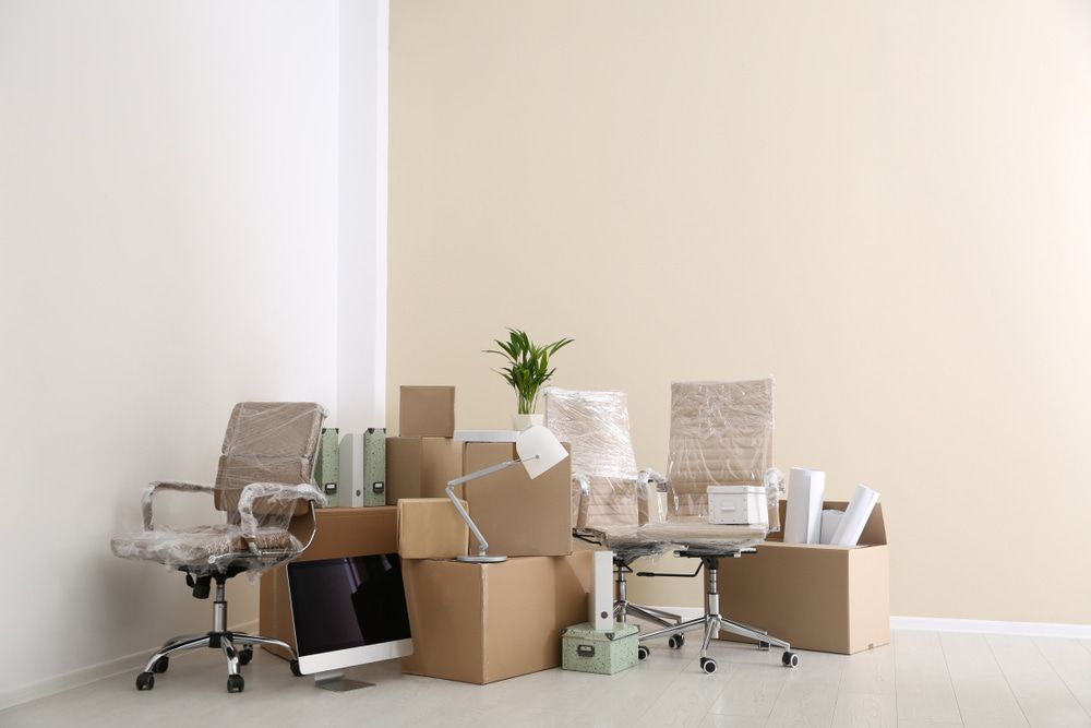 A Room Filled With Cardboard Boxes And Office Furniture — Newcastle Moving & Storage in Yarramalong, NSW