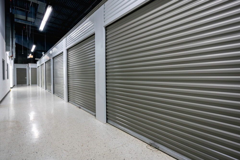 A Long Hallway With A Lot Of Rolling Doors — Newcastle Moving & Storage in Salt Ash, NSW