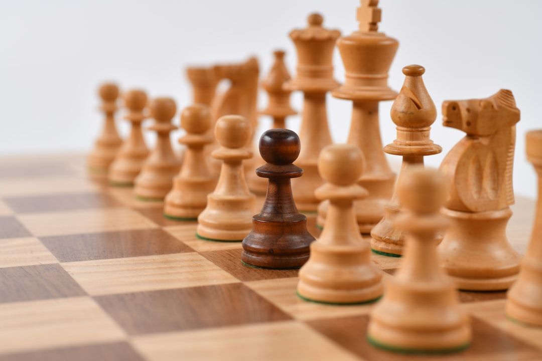 Chess board with white pieces arrayed against one black pawn in the center.