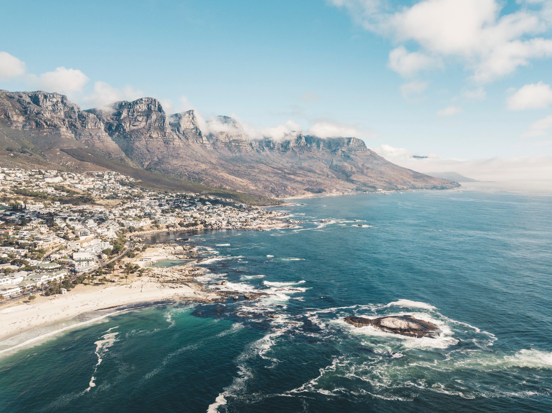 Aerial view of the Twelve Apostles mountain range rising above the coastline and Atlantic Ocean in Cape Town, South Africa.