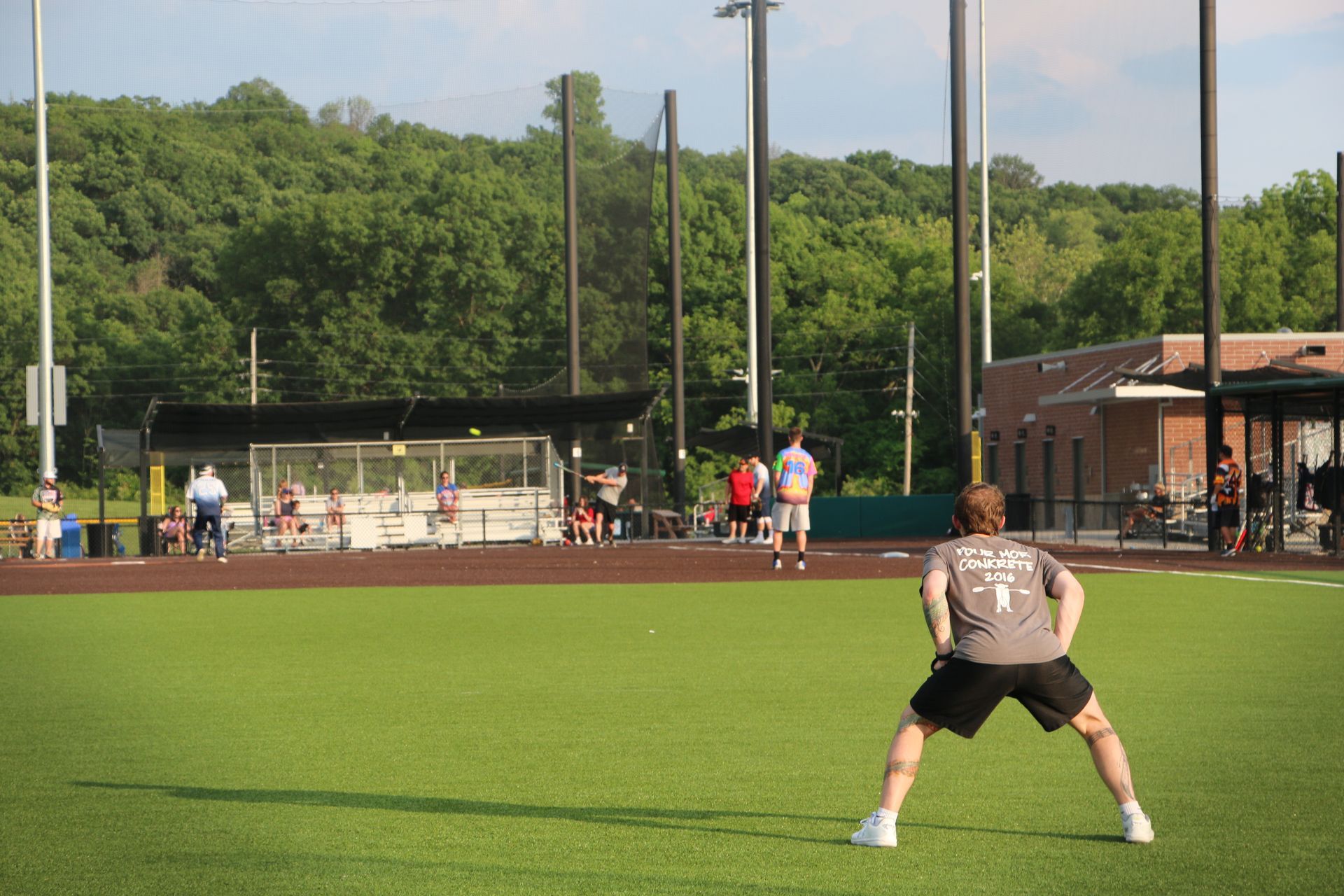 Two smiling boys with arms around each other in a park. One wears a track shirt, the other a striped shirt.