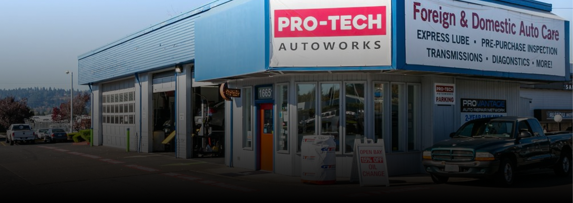 Pro-Tech Autoworks storefront with sign for foreign and domestic auto care, cars parked outside | Pro-Tech Autoworks