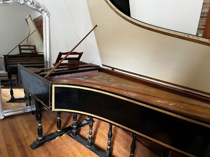 A piano is sitting in front of a mirror in a room