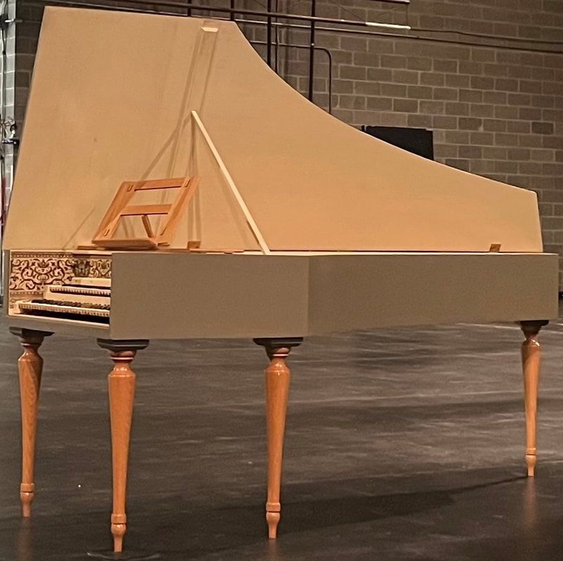 A piano is sitting on a stage in front of a brick wall