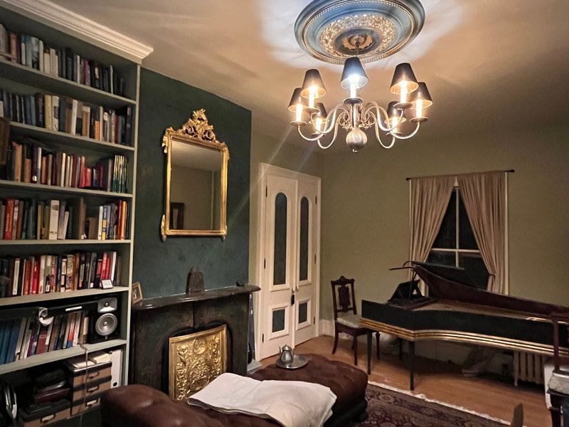 A living room with a piano and a chandelier