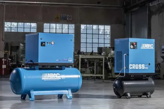 Compressori d'aria industriali blu e neri in un'officina