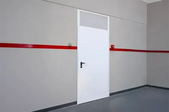 Una porta bianca in un corridoio grigio con una striscia rossa lungo la parete.