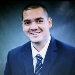 Fiduciary Derek Lewis in a tie is smiling.
