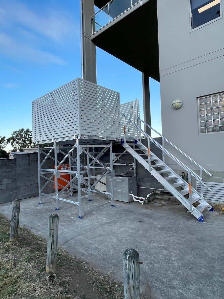 A set of stairs leading up to a balcony on the side of a building.