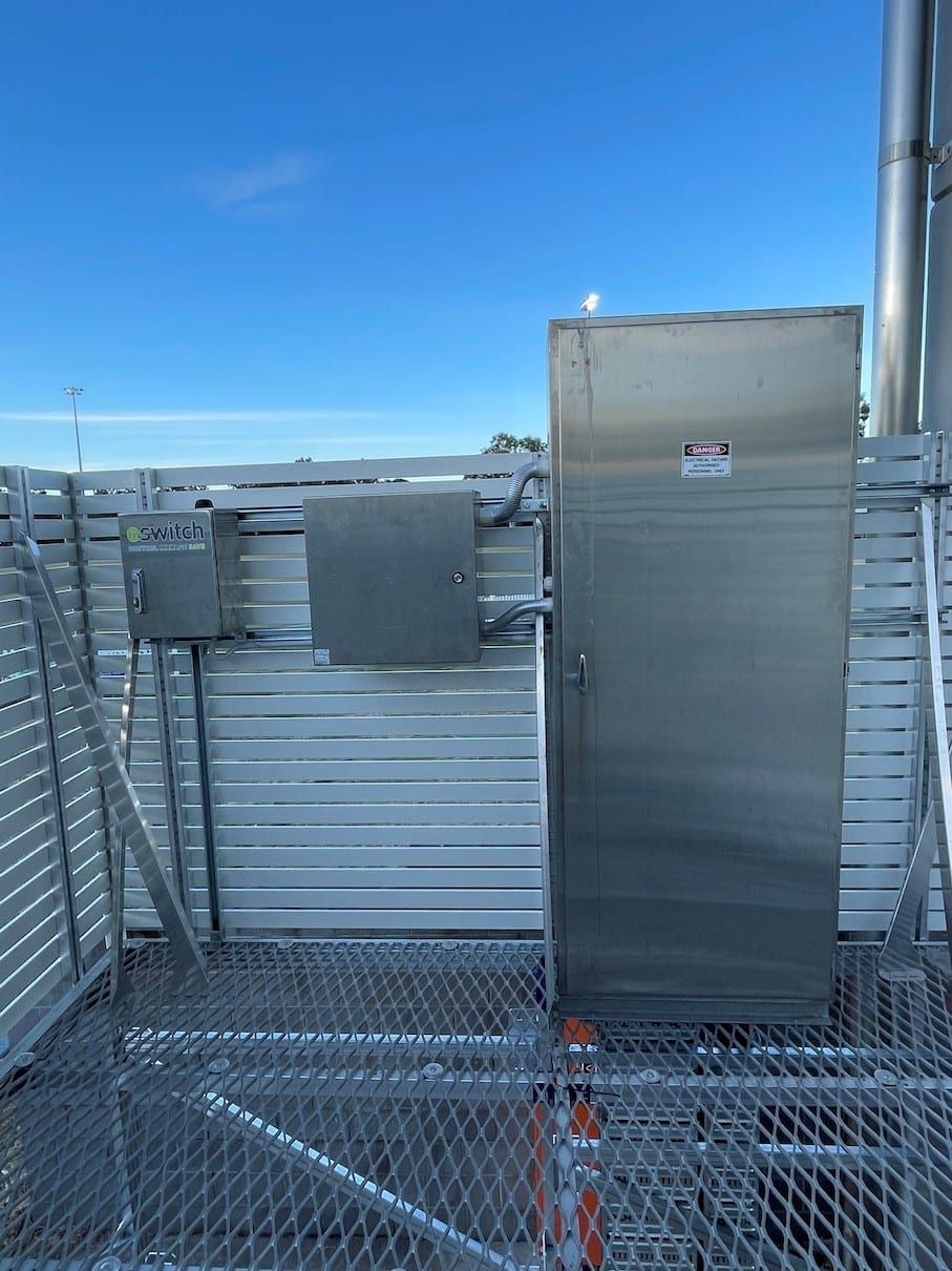 A stainless steel door is sitting on top of a metal fence.