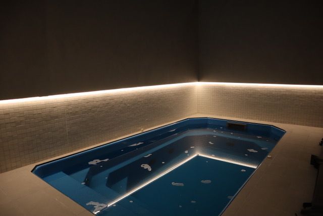 A large blue bathtub in a dark room