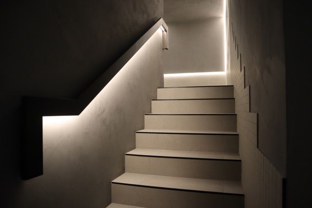 A set of stairs that are lit up in a dark room.