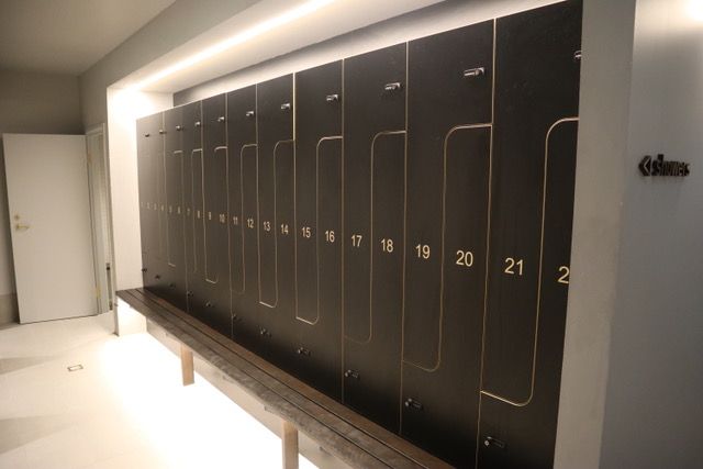 A row of black lockers with gold numbers on them