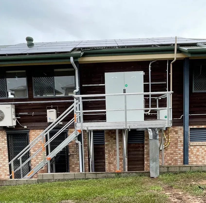 A house with a balcony and solar panels on the roof.