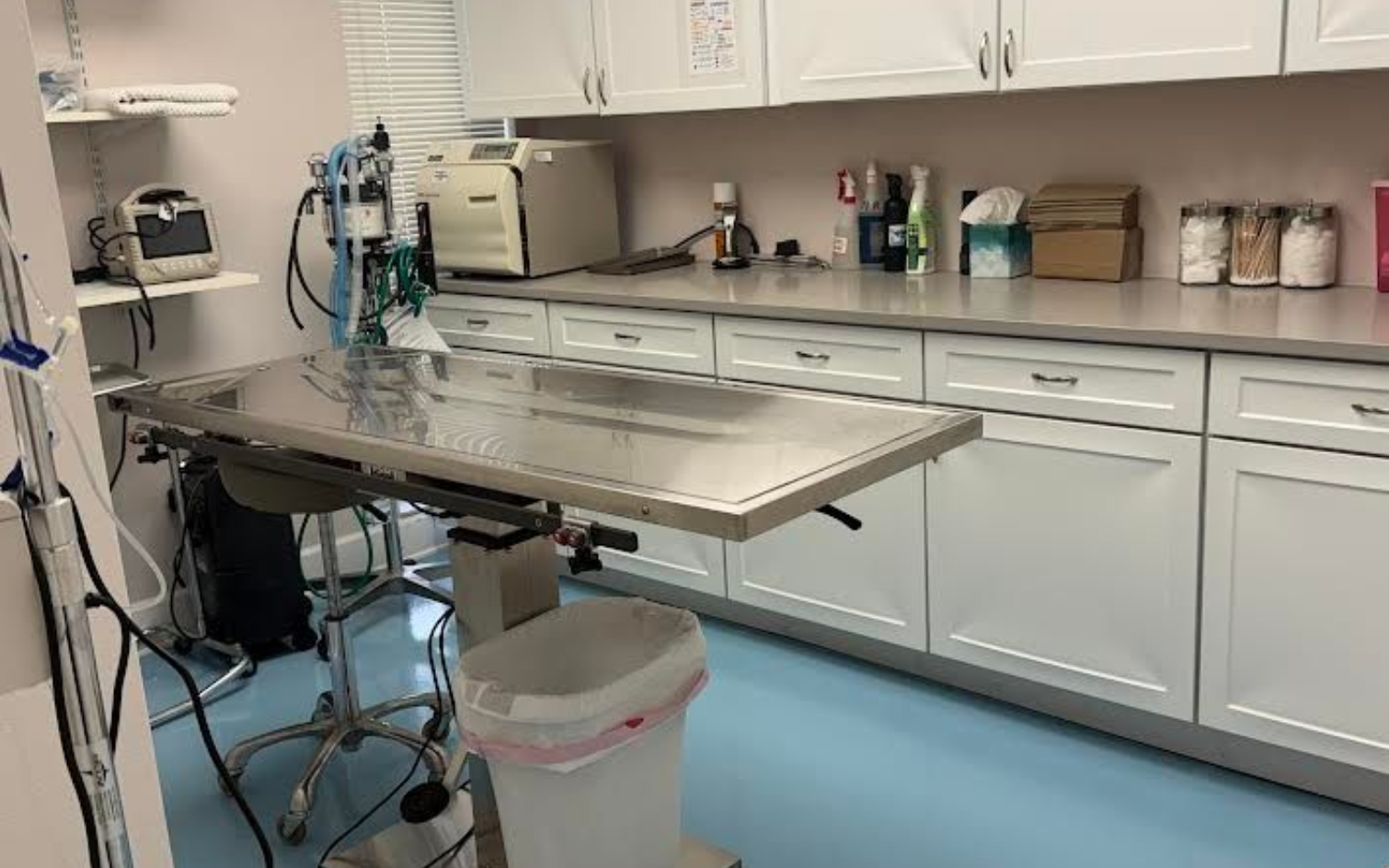 An empty operating room with a pink towel on the bed.