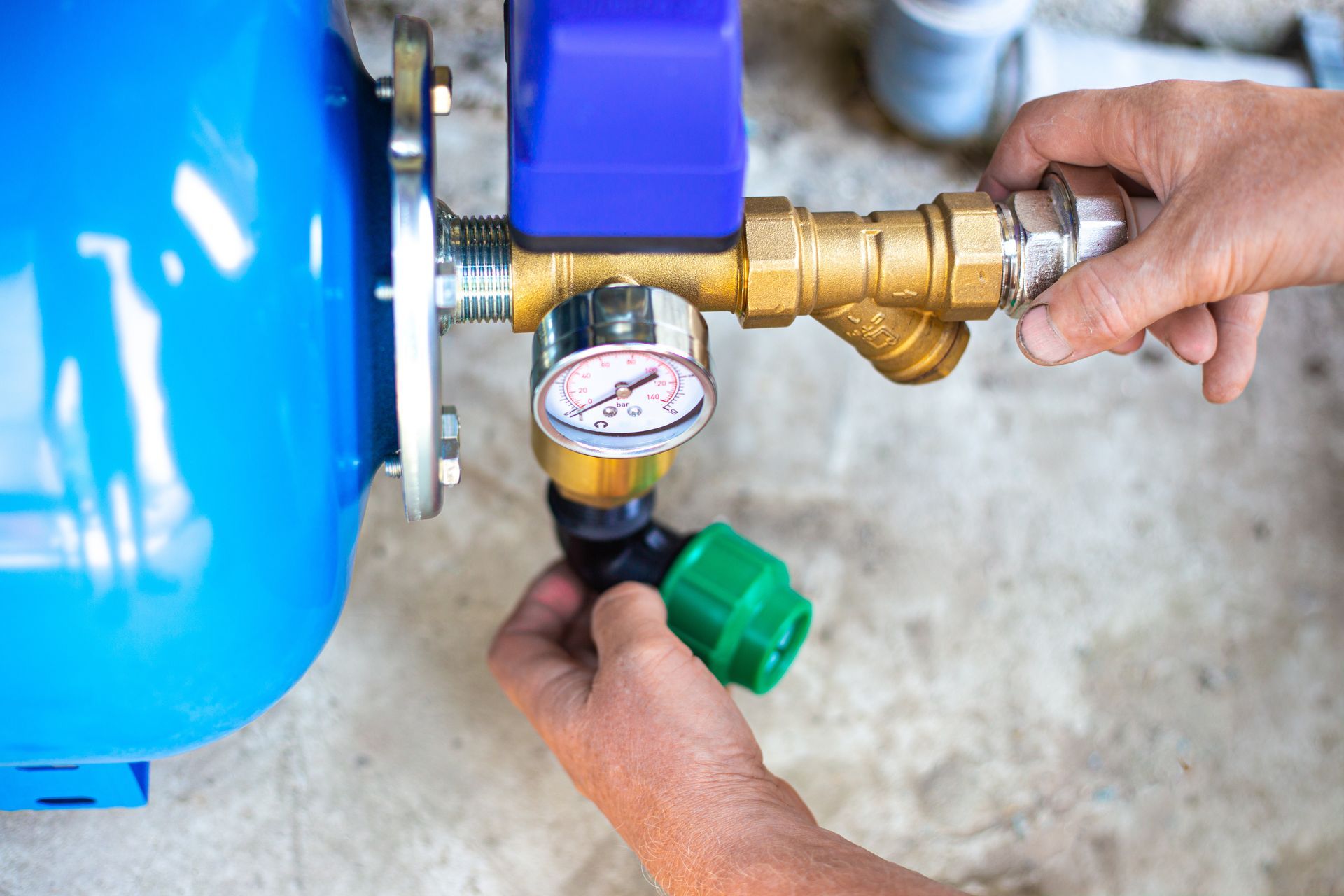 Hands adjusting a pressure gauge and fittings on a pump system during a repair. Hands adjusting a pressure gauge and fittings on a pump system during a repair.