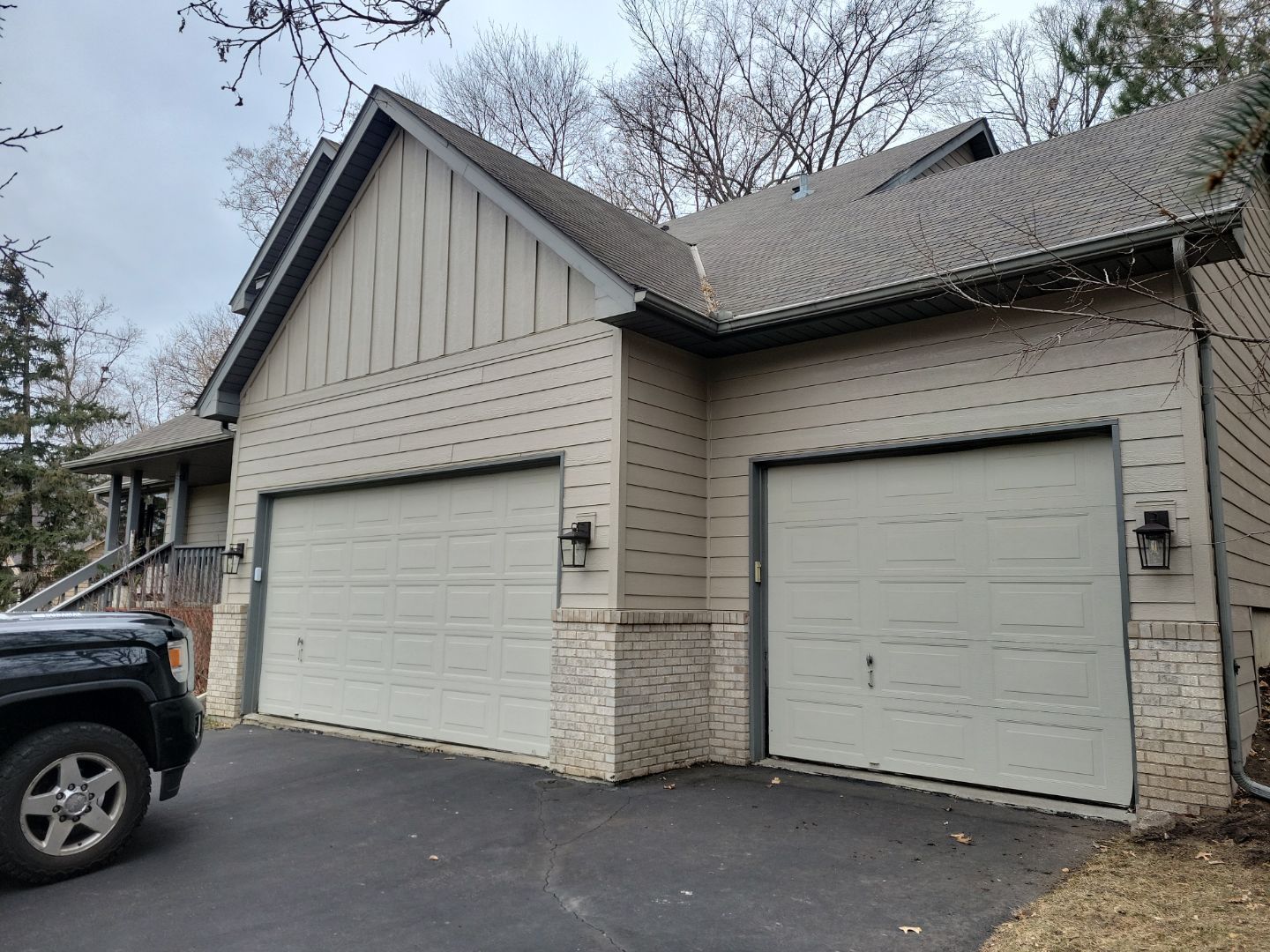a truck is parked in front of a house with two garage doors .