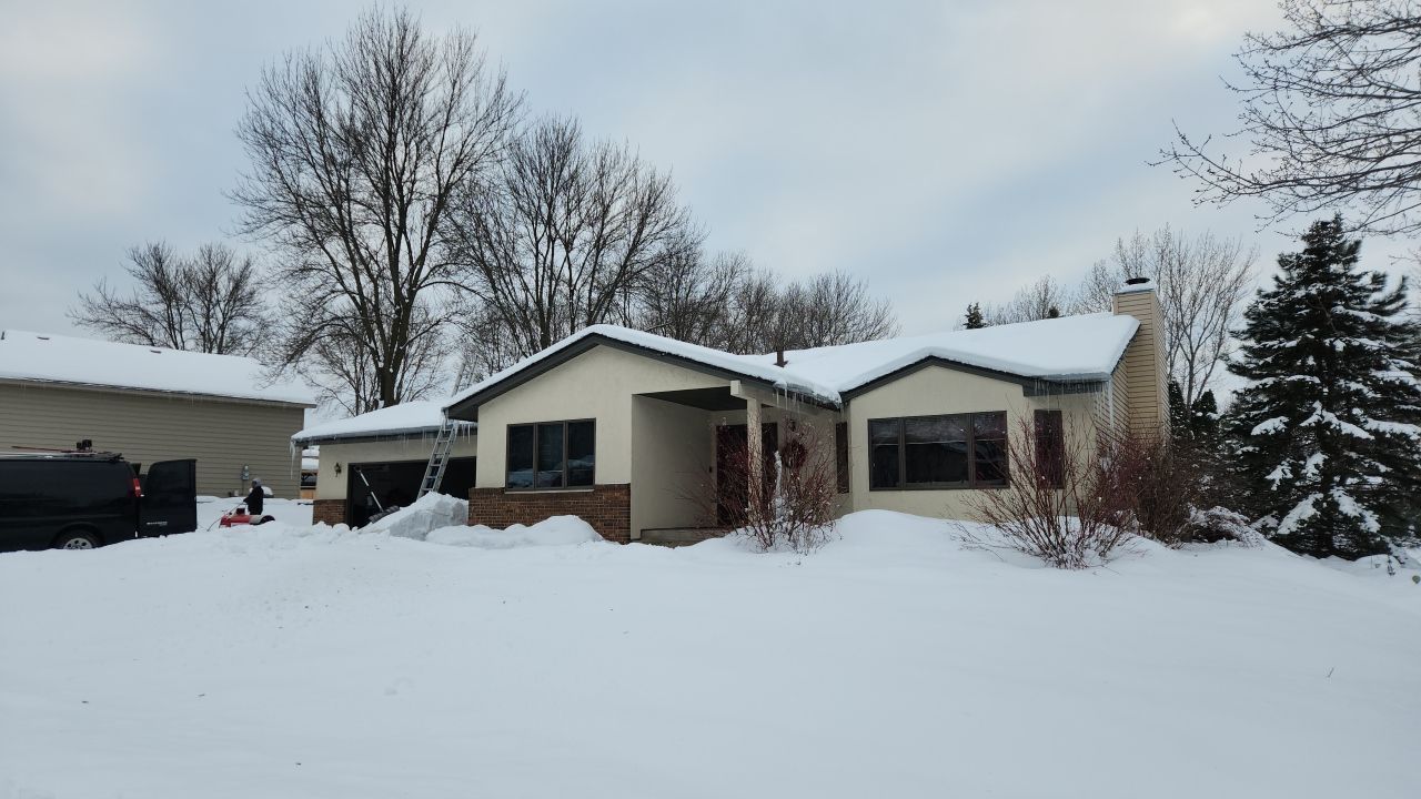 a house is covered in snow and trees are covered in snow .