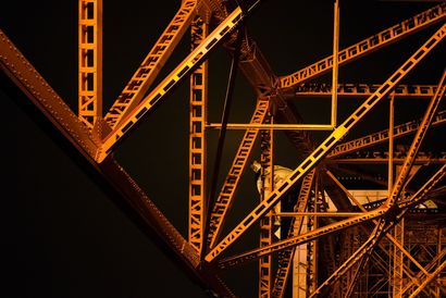 Orange-lit steel bridge trusses against a dark night sky