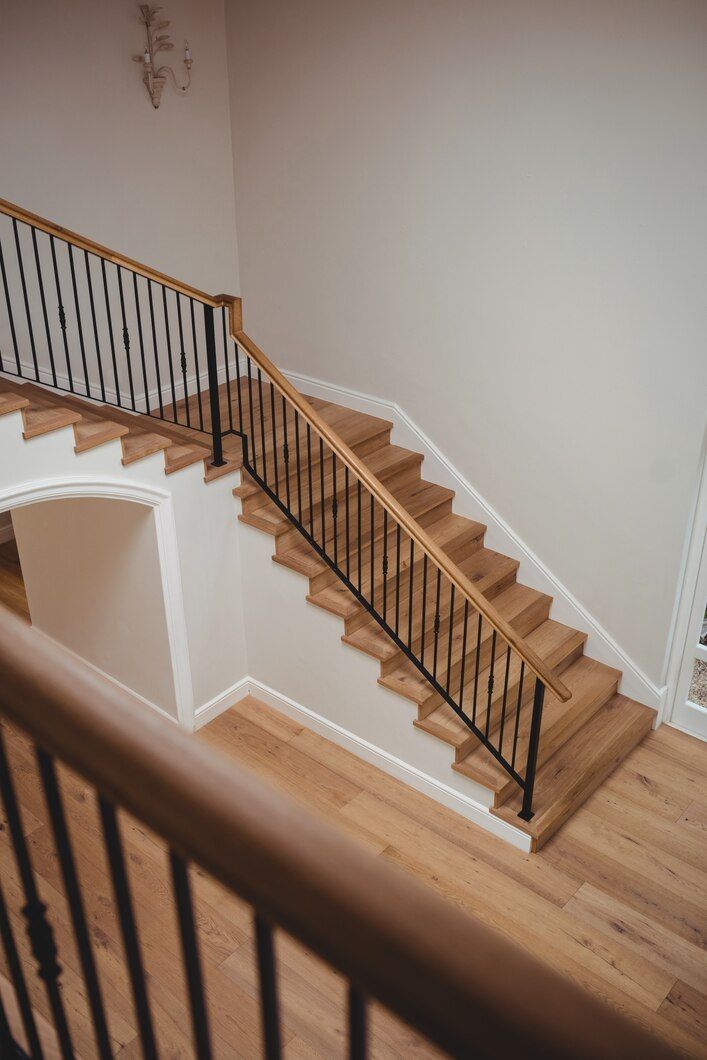 Staircase with wooden steps and black railings in a bright interior hallway