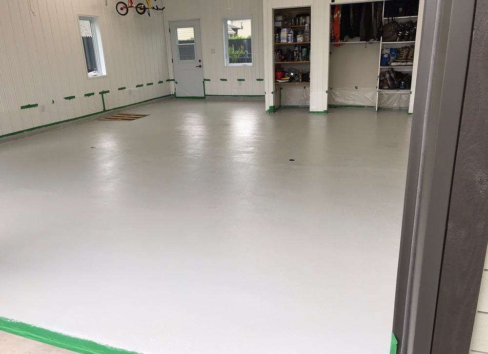 Un garage avec un sol blanc et des garnitures vertes.