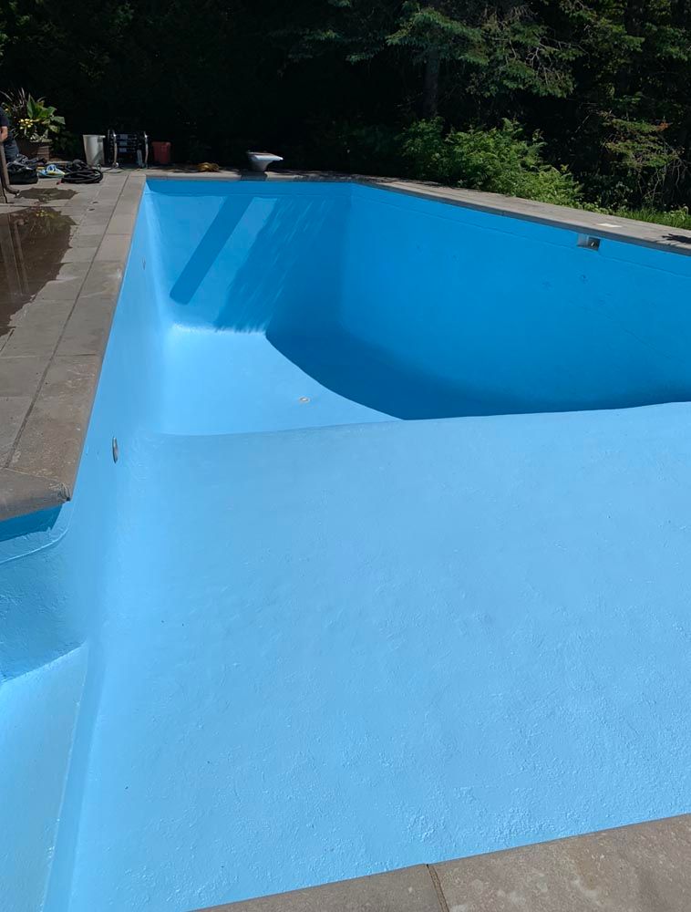 Une grande piscine bleue est en train d'être peinte en bleu.
