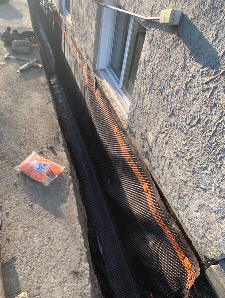 Un sac de sable est posé sur le sol à côté d'un bâtiment.
